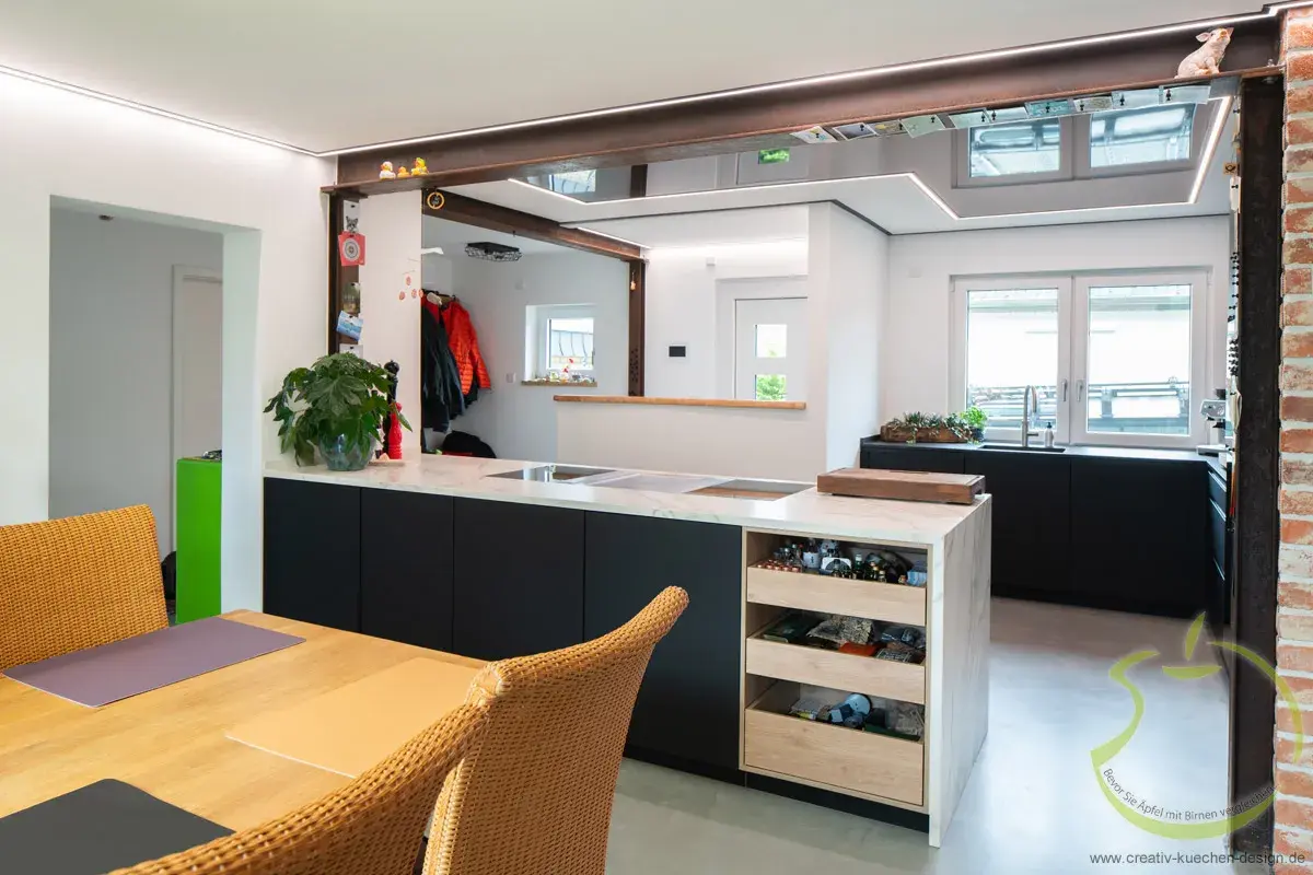 Moderne Wohnküche mit Esstisch, Kücheninsel und großen Fenstern, helle und freundliche Atmosphäre.