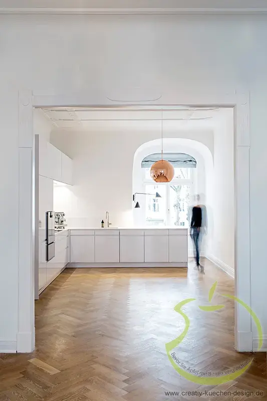 Helle, moderne Küche mit Holzfußboden und großer Fensterfront.